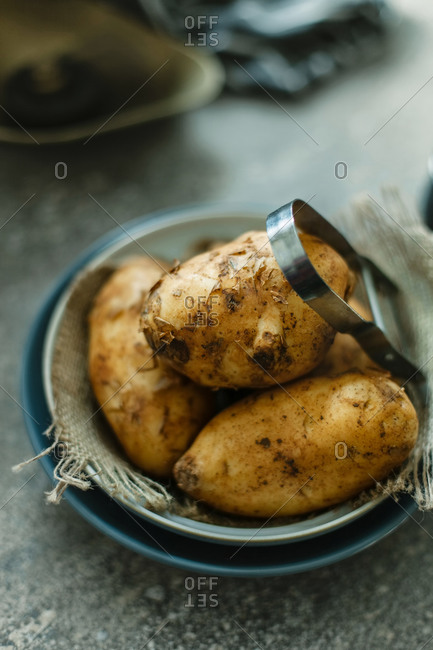 Freshly picked potatoes in a bowl with burlap