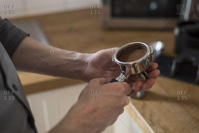 Preparing a cappuccino, coffee filter, pressed coffee powder in portafilter