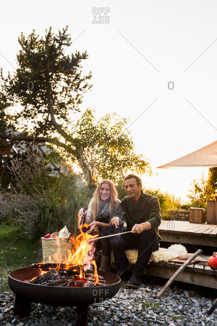 Couple sitting by fire pit in garden