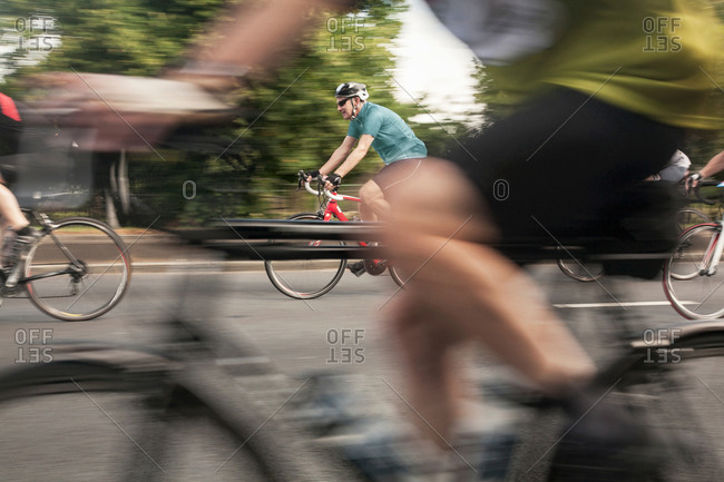 Close up of racing cyclists speeding on urban road in racing cycle race