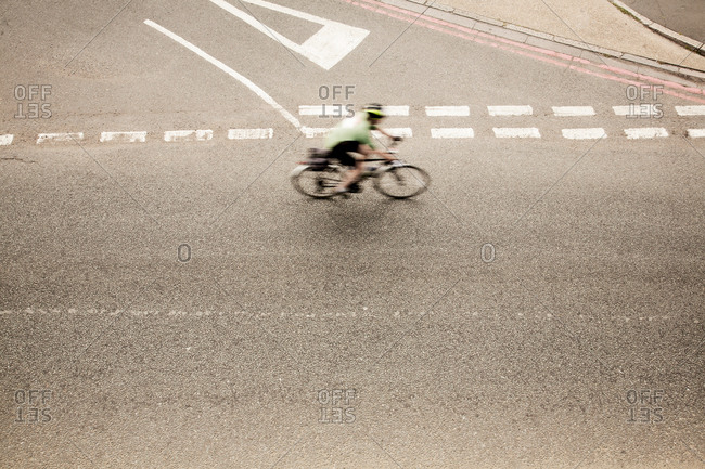 Overhead view of racing cyclist speeding on urban road in racing cycle race
