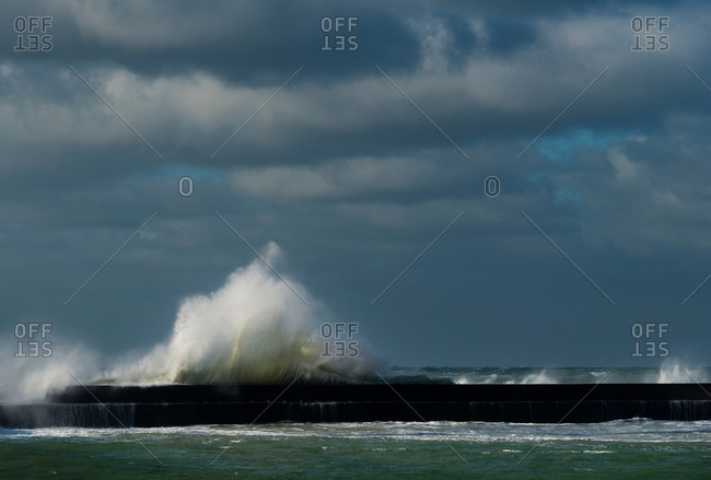 Stormy sky and ocean waves splashing harbor wall, Boulogne-Sur-Mer, Pas de Calais, France