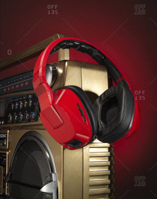Close-up of red headphones hanging on the edge of a vintage boombox