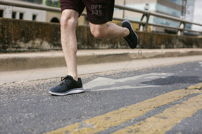 Person wearing athletic shoes while running on the street