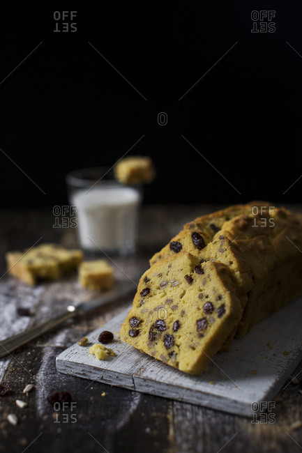 Buttery gluten free cake slices with raisins and sunflower seeds on a cutting board