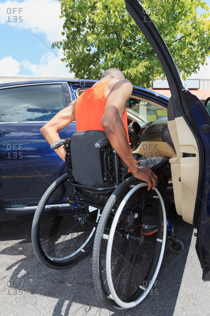 Man in wheelchair getting into a car