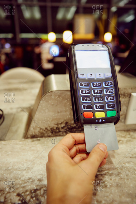 Woman\'s hand using credit card machine for restaurant  payment