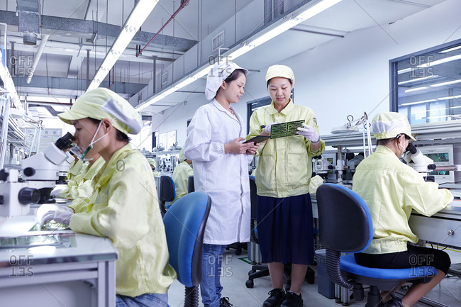 Supervisor at quality check station at factory producing flexible electronic circuit boards