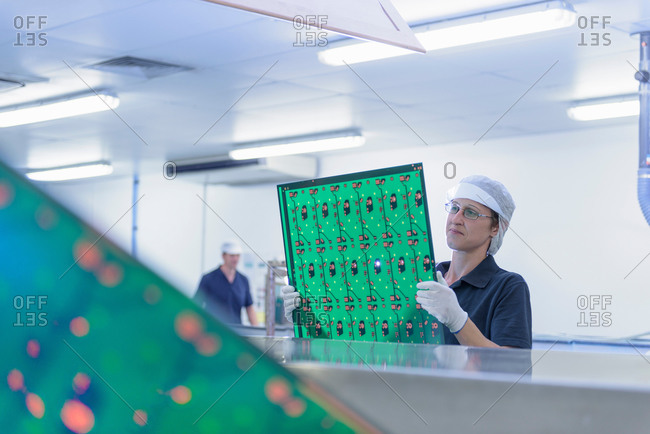Female worker inspecting circuit boards