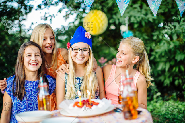 Girls with birthday cake at summer garden party