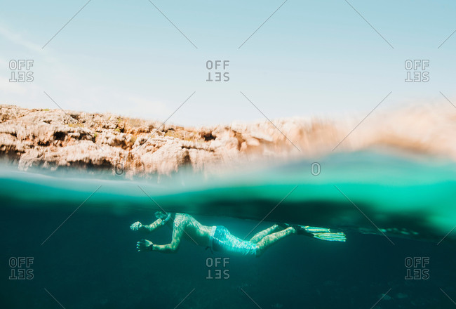Underwater surface view of mature man sea snorkeling, Menorca, Balearic islands, Spain