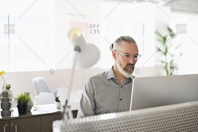 Man sitting in a bright, modern office using a desktop computer