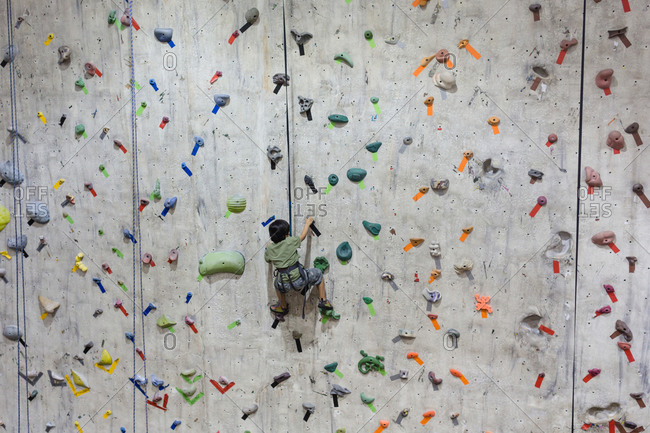 Boy climbing an indoor rock wall
