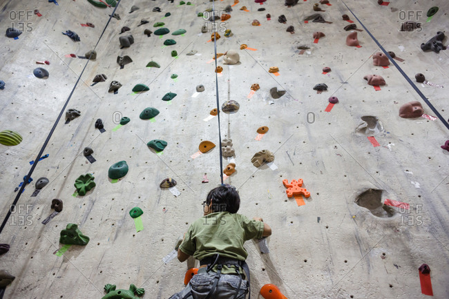 Boy scaling an indoor rock wall