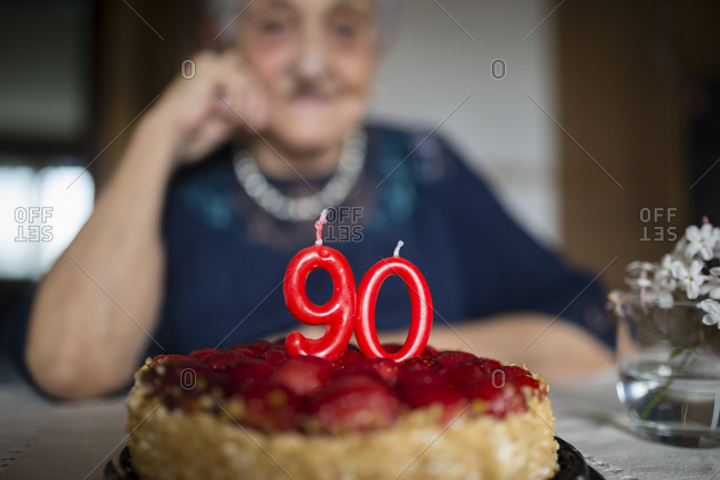 Candles on a birthday cake of a senior woman celebrating her ninetieth birthday