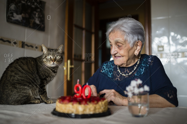 Senior woman celebrating ninetieth birthday with her cat