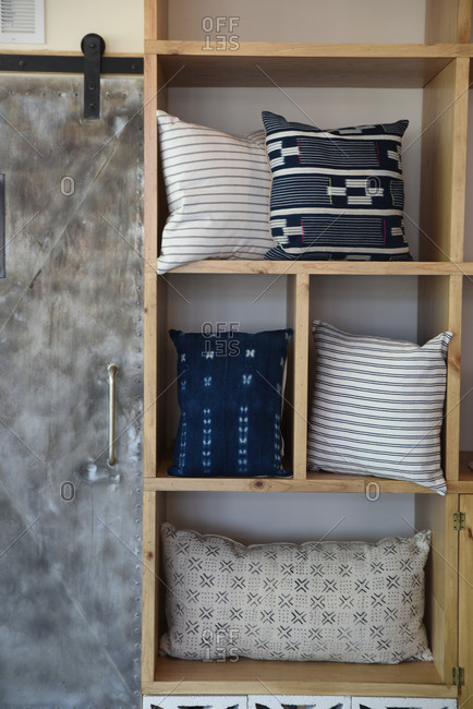 Throw pillows displayed on a wood shelving unit