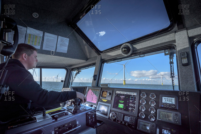 Captain of boat steering through offshore wind farm