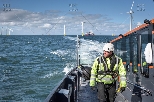 Crew member walking on deck of boat on offshore wind farm
