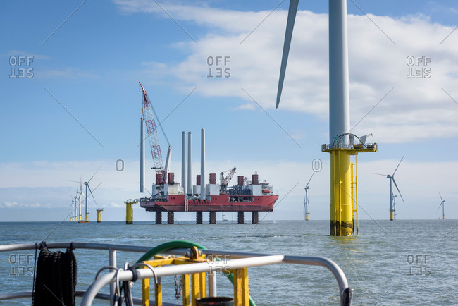 View from boat of offshore wind farm and construction ship