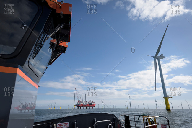 View of offshore wind farm and construction ship from boat