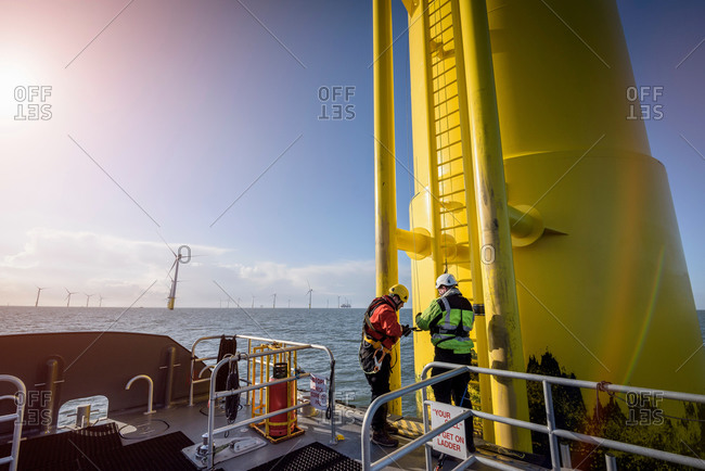 Engineers preparing to climb wind turbine at offshore wind farm