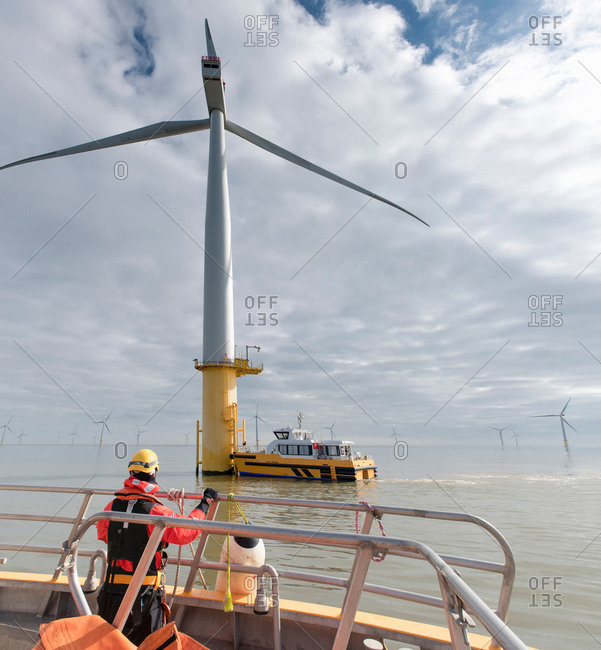 Engineer in boat at offshore windfarm turbine