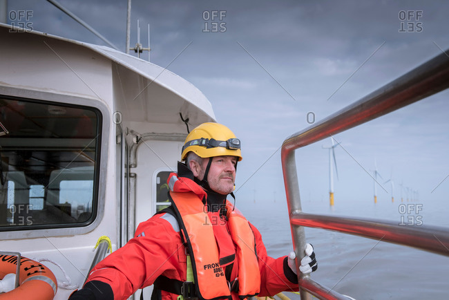 Portrait of engineer on boat at offshore windfarm