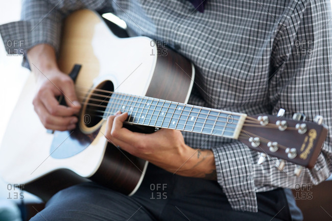 Close up of man playing an acoustic guitar