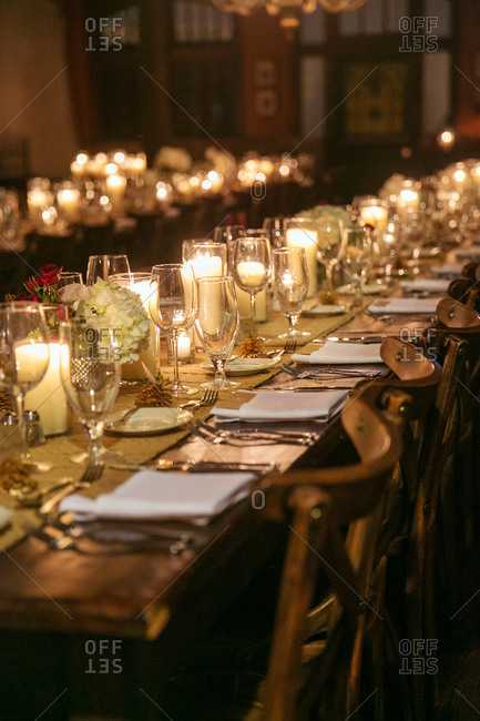 Long table set with candles, flowers, and table runner