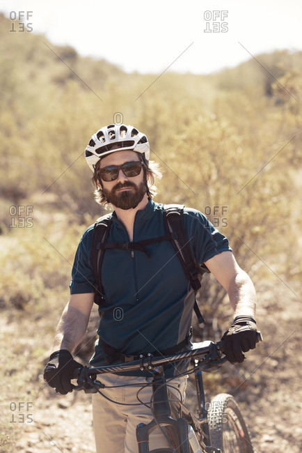 Portrait of a man with a mountain bike in the desert
