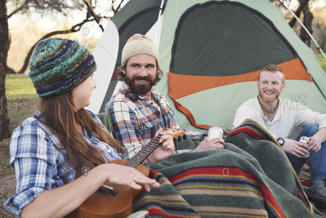Friends hanging out and playing ukulele on a camping trip