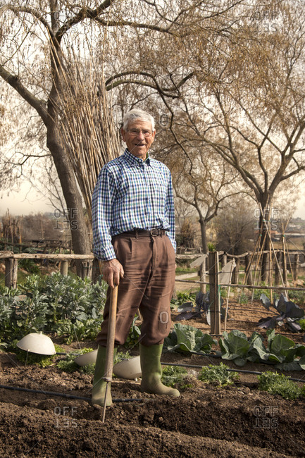 Portrait of an old man standing in his garden