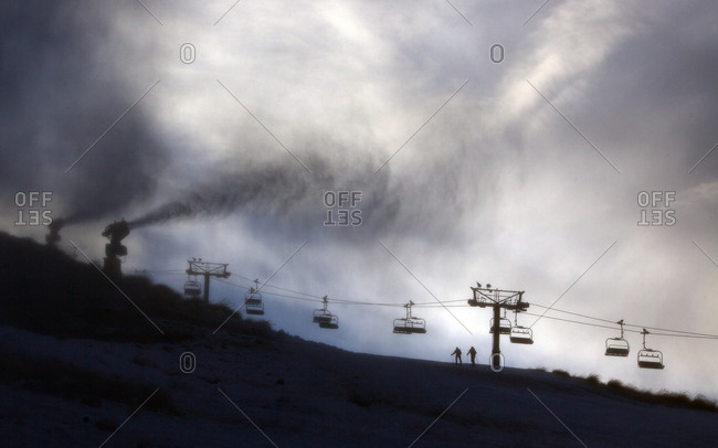 Snow making machines throwing ski over the chair lift at Coronet Peak ski field, Coronet Peak, Queenstown, South Island, New Zealand