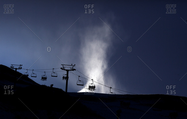 Silhouette of the ski lifts and a snow machine blowing snow at Coronet Peak, Queenstown,  South Island, New Zealand