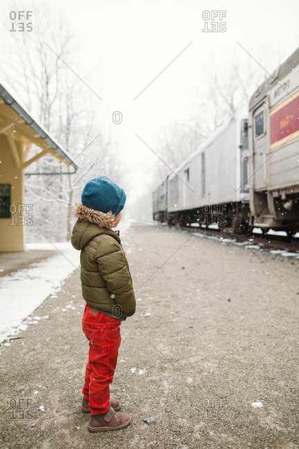 Boy in snow on train platform