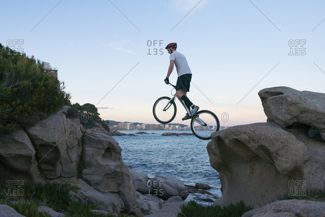 Bmx rider jumping from rock to  rock in the evening
