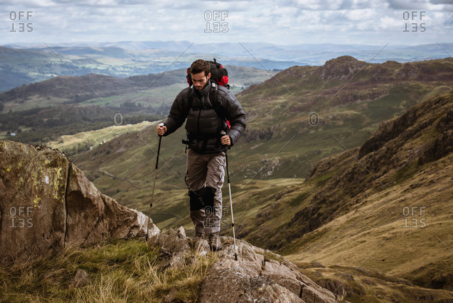 Young male hiker moving up mountain, The Lake District, Cumbria, UK