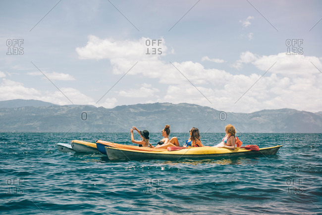 Four young female friends kayaking on Lake Atitlan, Guatemala