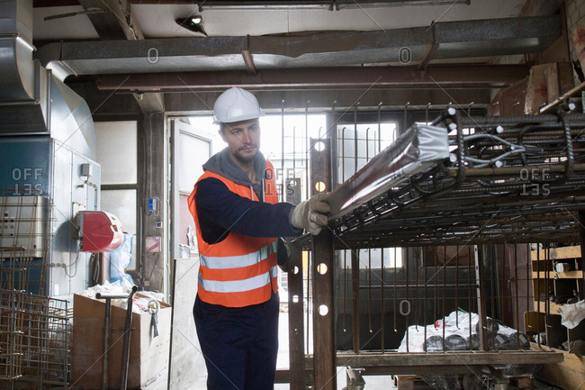 Factory worker selecting steel mesh in concrete reinforcement factory