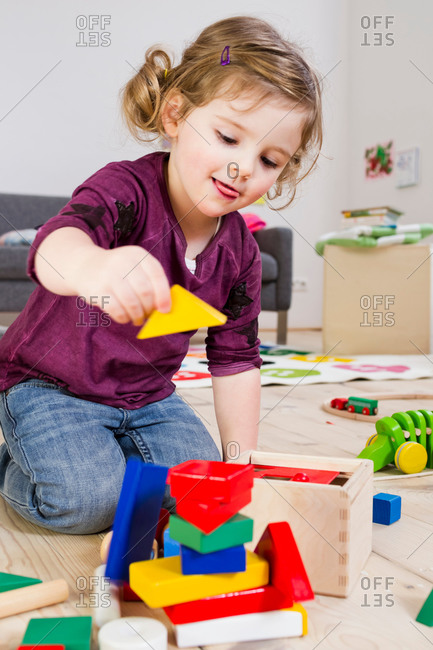 Girl playing with building blocks at home