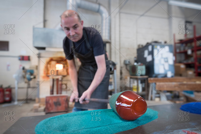 Glassblower adding colour to hot glass
