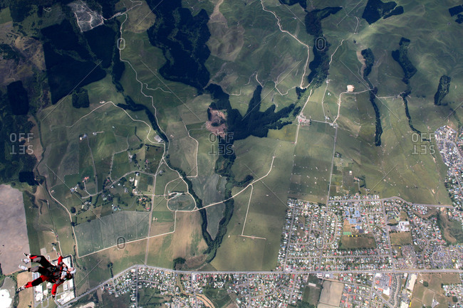 Skydivers over a patchwork of fields and neighborhoods near Rotorua, New Zealand