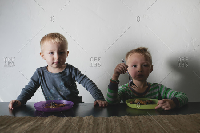 Boys staring while eating at table