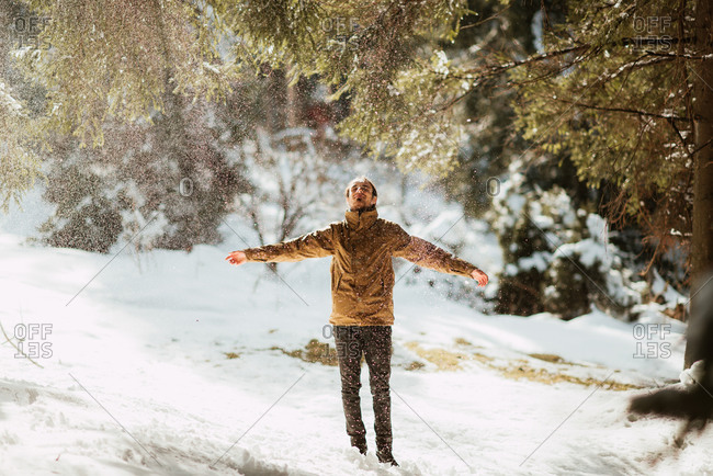 Man enjoying a spray of snow in the forest