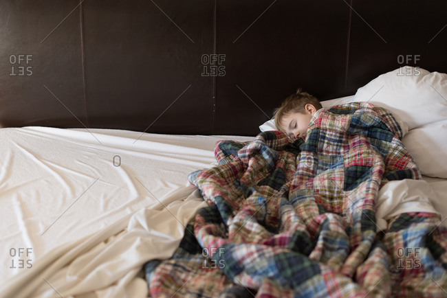 Boy asleep under blankets