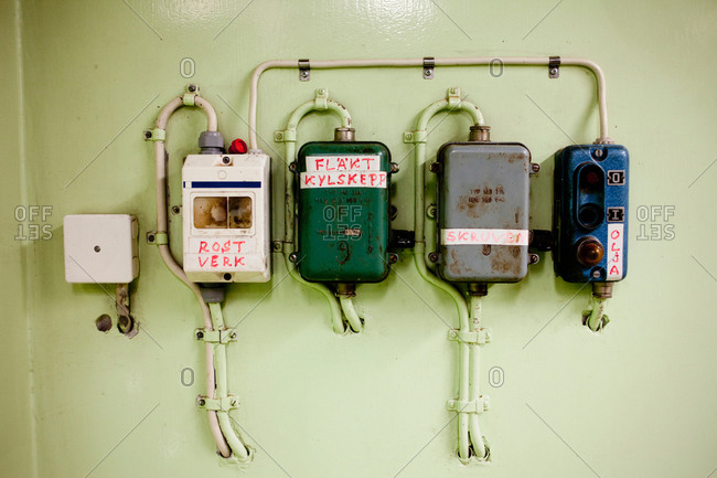 Electrical meters and boxes on green wall