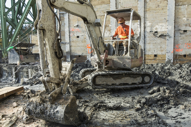 Worker using digger at construction site