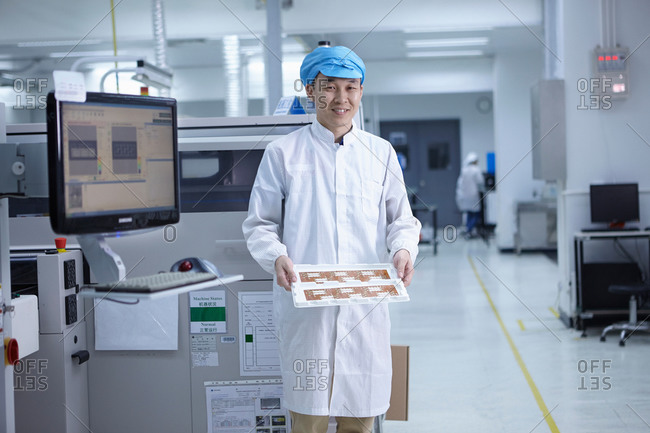 Portrait of worker in factory showing functional circuits on flexible surfaces