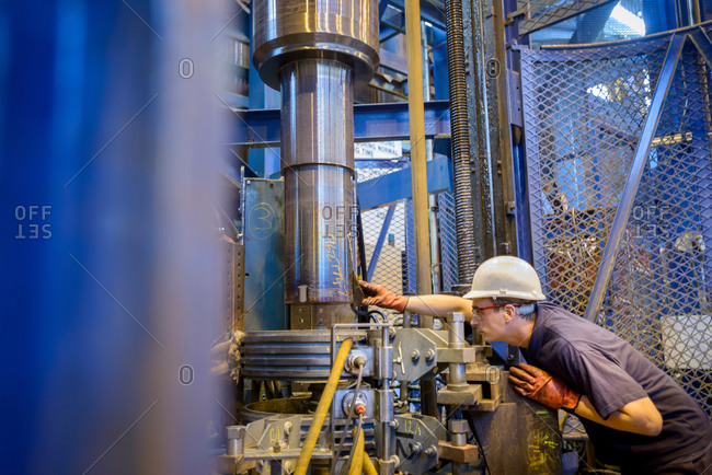 Engineer heat treating steel parts in induction furnace in engineering factory